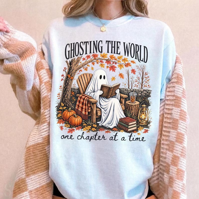 Ghost reading outdoors with pumpkins and autumn leaves